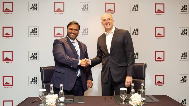 Greg Fewer, Aldar chief financial and sustainability officer, right, with Benoy Kurien, chief executive of Al Hamra Group, at the signing ceremony. Photo: Aldar