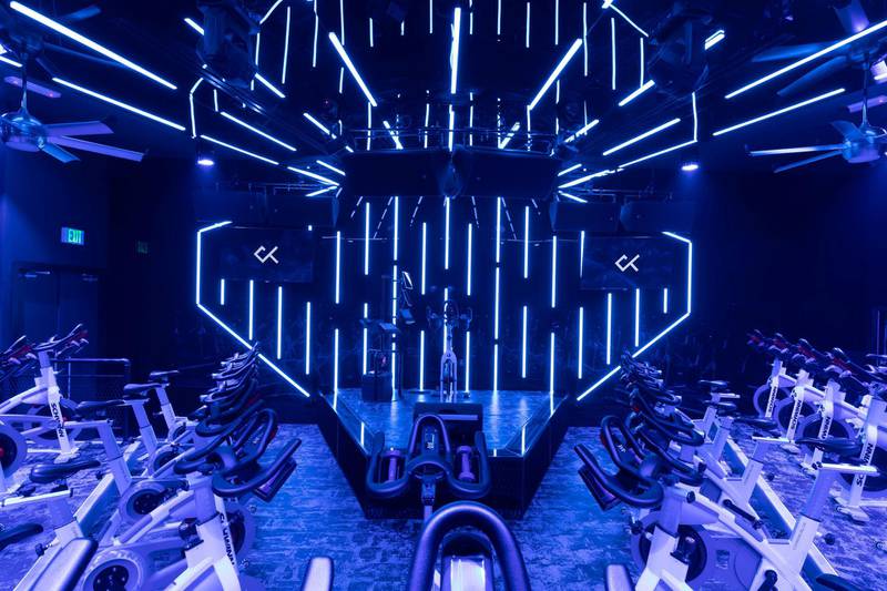 Spin studio Crank is set in a nightclub environment with a DJ spinning party tracks