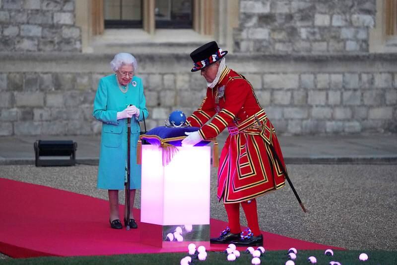 Britain's Queen Elizabeth II prepares to touch the Commonwealth Nations Globe to start the lighting of the principal beacon outside of Buckingham Palace in London, from the Quadrangle at Windsor Castle in Windsor, west of London, as part of Platinum Jubilee celebrations on June 2, 2022 in Windsor, England. Getty