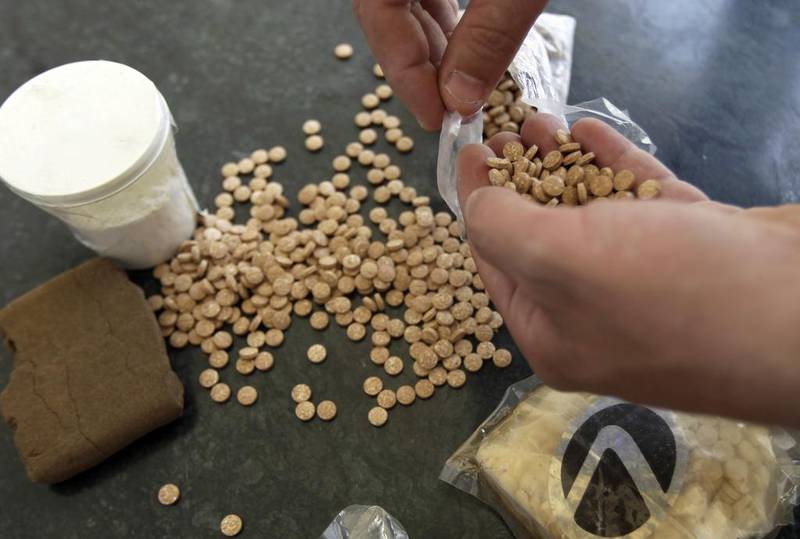 Captagon pills displayed along with a cup of cocaine and hashish at an office of the Lebanese Internal Security Forces (ISF), Anti-Narcotics Division in Beirut on June 11, 2010. Joseph Eid / AFP Photo