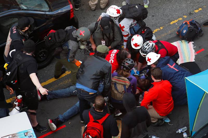 Medics tend to a man who was shot in the arm by a driver of a black vehicle at a protest against racial inequality in the aftermath of the death in Minneapolis police custody of George Floyd, in Seattle, Washington, U.S. June 7, 2020. Picture taken June 7, 2020. REUTERS/Lindsey Wasson