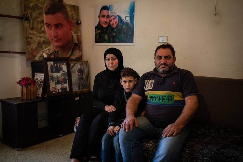 Salam Iskandar, her husband, Jaber, and their son, Ali, sit in their living room in Borj El Brajneh in the southern suburbs of Beirut, surrounded by photographs of Salam's brother, Hamza, who died in the Beirut port blast. All photos: Oliver Marsden / The National
