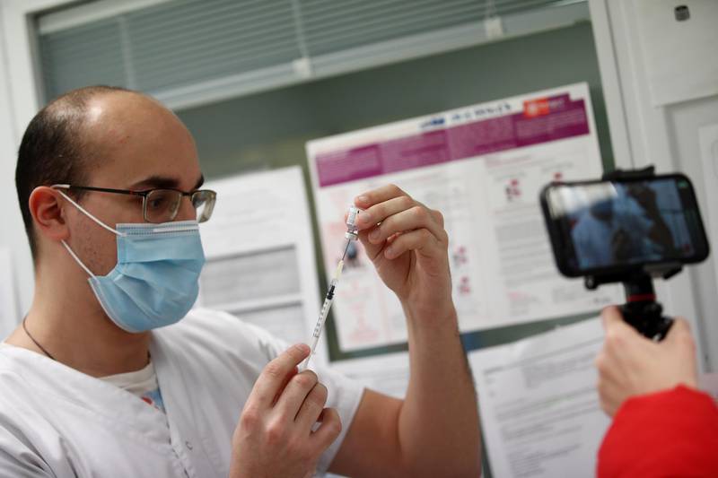 A journalist films a medical worker drawing the Pfizer-BioNTech vaccine from a vial at the Max Fourastier hospital in Nanterre, France. Reuters