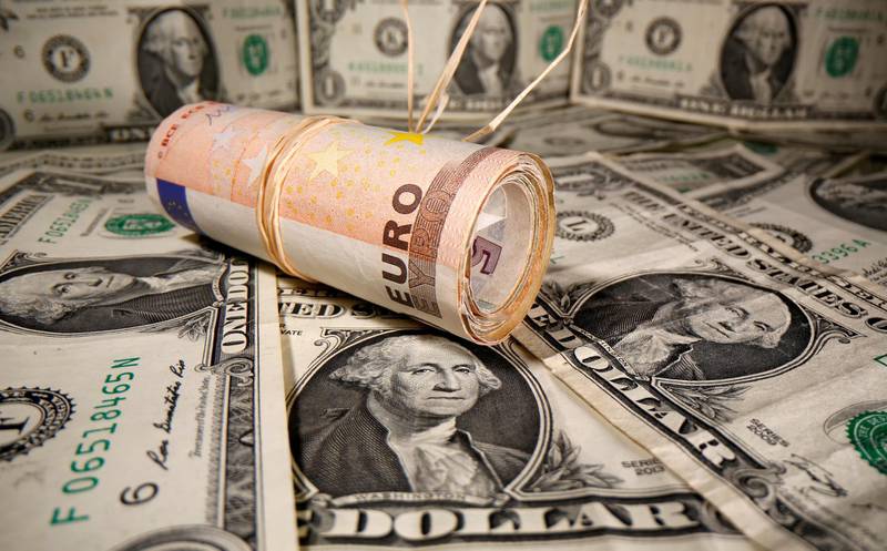 FILE PHOTO: Rolled Euro banknotes are placed on U.S. Dollar banknotes in this illustration taken May 26, 2020. REUTERS/Dado Ruvic/Illustration/File Photo