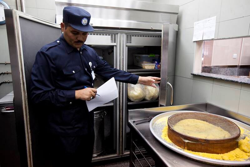 ABU DHABI, UAE - July 27, 2011-  Mansour Adb El Latif, of the Abu Dhabi Food Control Authority's Department of Field Operations, looks inside a refrigerator at Qwaider Al Nabulsi Sweets during an inspection while looking for violations of the health code on Wednesday July 27, 2011.  (Andrew Henderson / The National) 