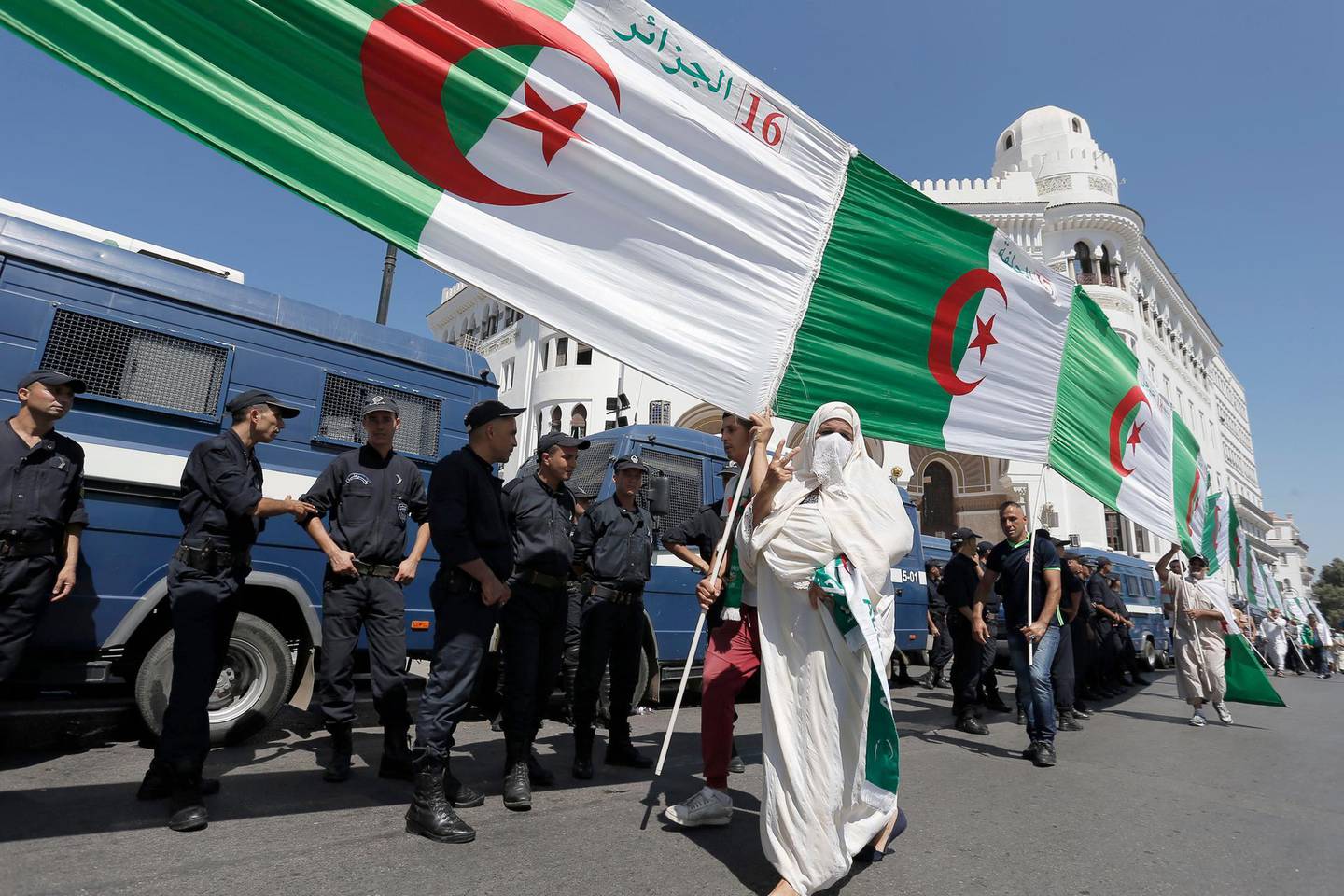 Algerian demonstrators carry a huge national flag in the capital Algiers to protest against the government, in Algeria, Friday, Aug. 16, 2019 (AP Photo/Toufik Doudou)