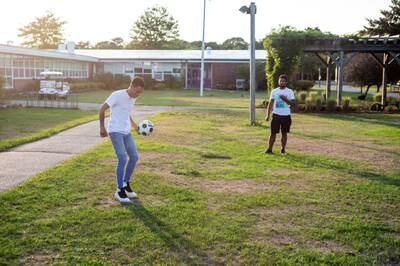Venezuelan migrants play football outside the Martha's Vineyard Regional High School, Massachusetts. Reuters