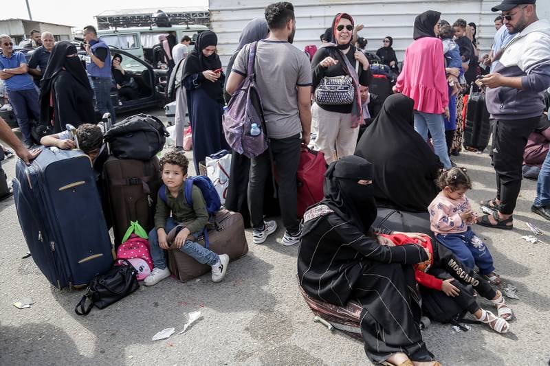 Palestinians with dual nationalities wait to cross the border from Gaza into Egypt at Rafah on Monday. EPA