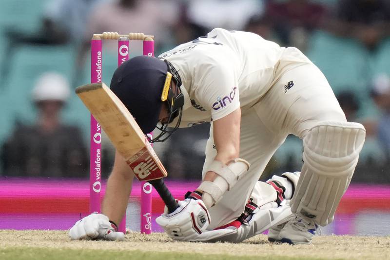 England's Mark Wood is knocked down by a yorker from Australia's Pat Cummins and is LBW during the fifth day of their Ashes cricket test match in Sydney, Sunday, Jan.  9, 2022.  (AP Photo / Rick Rycroft)
