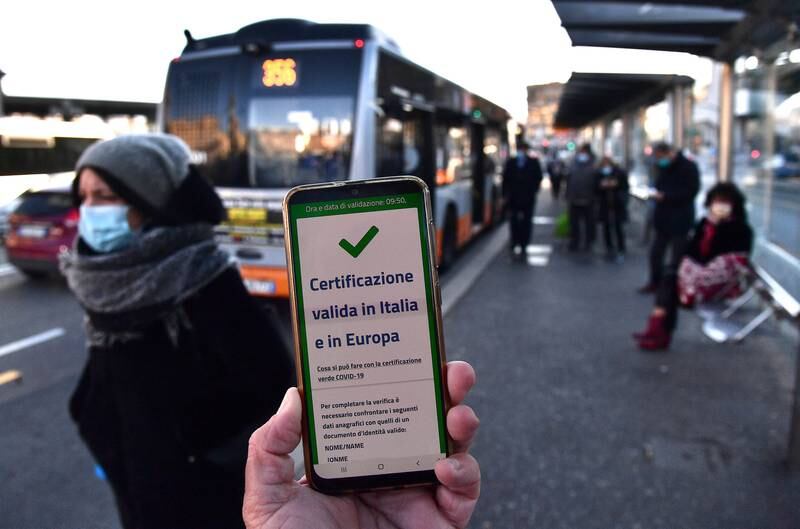 A passenger shows green pass on his mobile phone at Brignole bus stop in Genoa, Italy. EPA