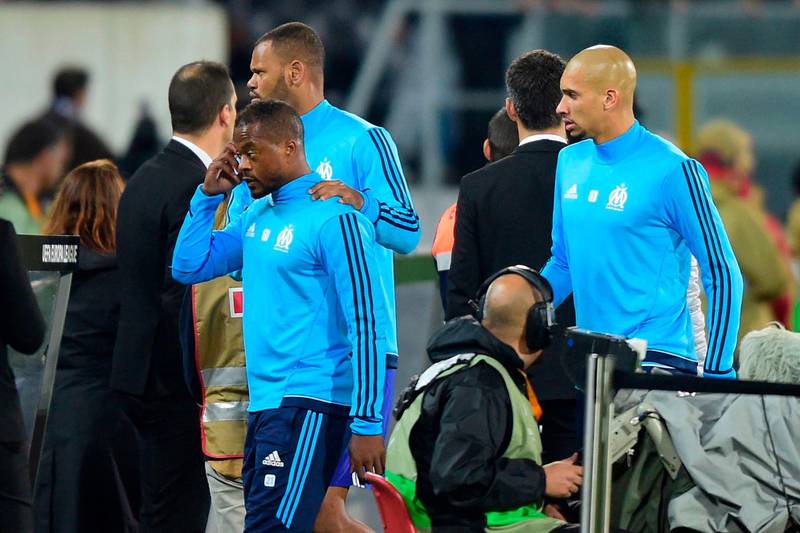 Marseille's French defender Patrice Evra (C) is escorted off the pitch by teammates Portuguese defender Rolando and Brazilian defender Doria (R) after an argument with supporters before the start of the UEFA Europa League group I football match Vitoria SC vs Marseille at the D. Afonso Henriques stadium in Guimaraes on November 2, 2017. / AFP PHOTO / MIGUEL RIOPA