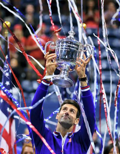 Novak Djokovic of Serbia celebrates with his winning trophy after defeating Roger Federer of Switzerland during of their 2015 US Open Men's singles final match at the USTA Billie Jean King National Tennis Center in New York on September 13, 2015. AFP PHOTO/JEWEL SAMAD (Photo by JEWEL SAMAD / AFP)