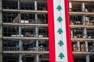 A banner with representations of the Lebanese flag hangs on a damaged building in a neighbourhood near the scene of last week's explosion that hit the seaport of Beirut, Lebanon, Wednesday, August 12, 2020. AP Photo