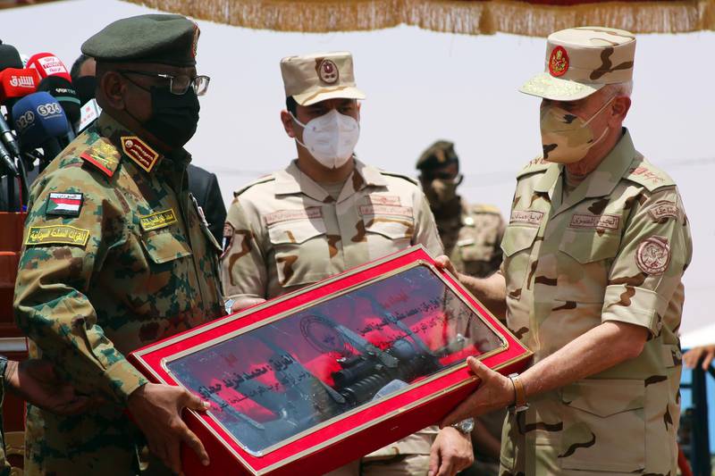 Sudanese Chief of Staff Muhammad Al Hassan (left) hands over a Sudanese-made weapon to Egyptian Chief of Staff Muhammad Farid during the 'Guardians of the Nile' military exercises in southern Sudan. EPA
