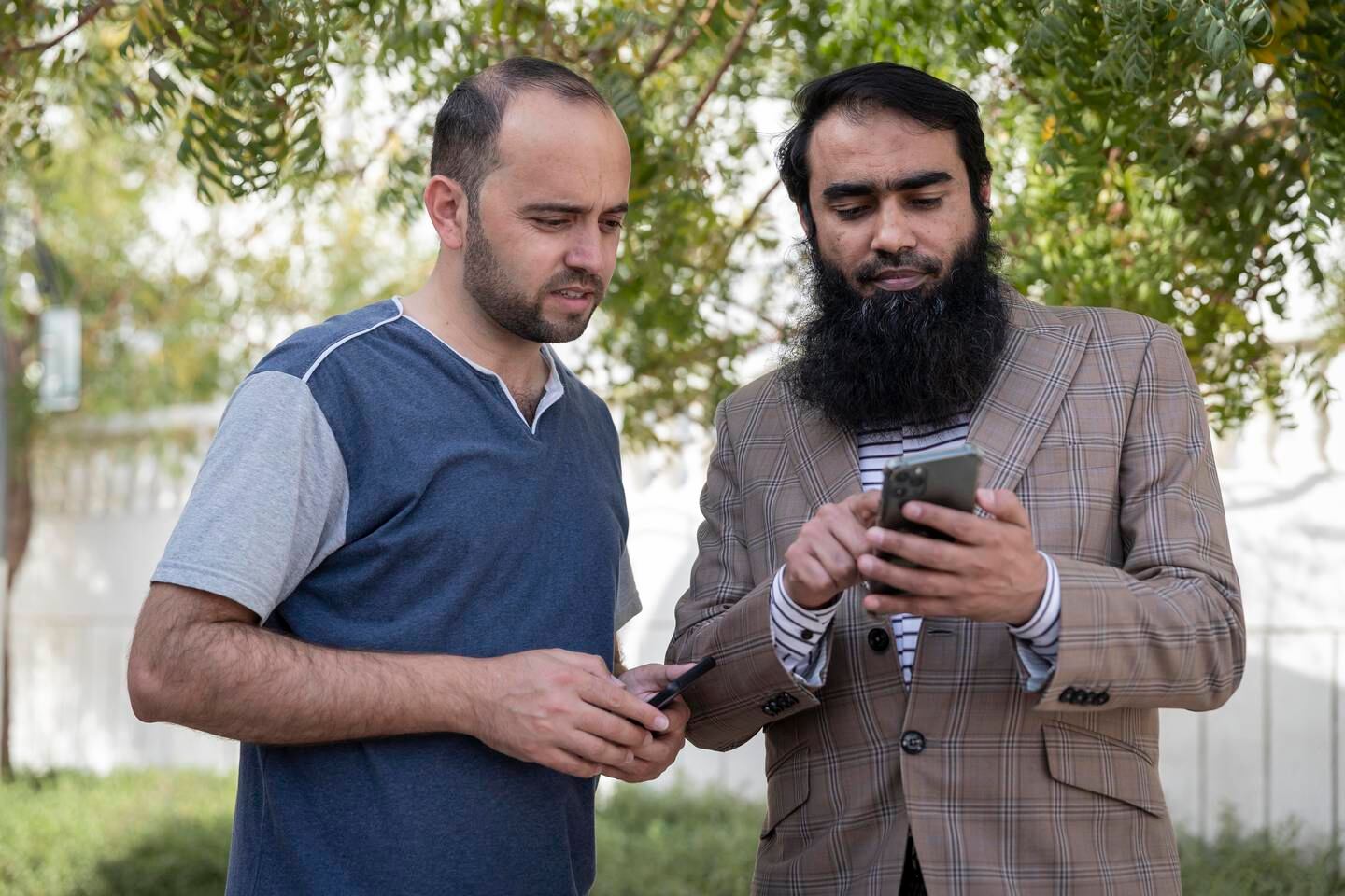 Indian software expert Abu Muadh, right, launched an app in Dubai to help workers such as Abdul Qadeer, from Pakistan, learn English and other skills to open up work opportunities. Antonie Robertson / The National