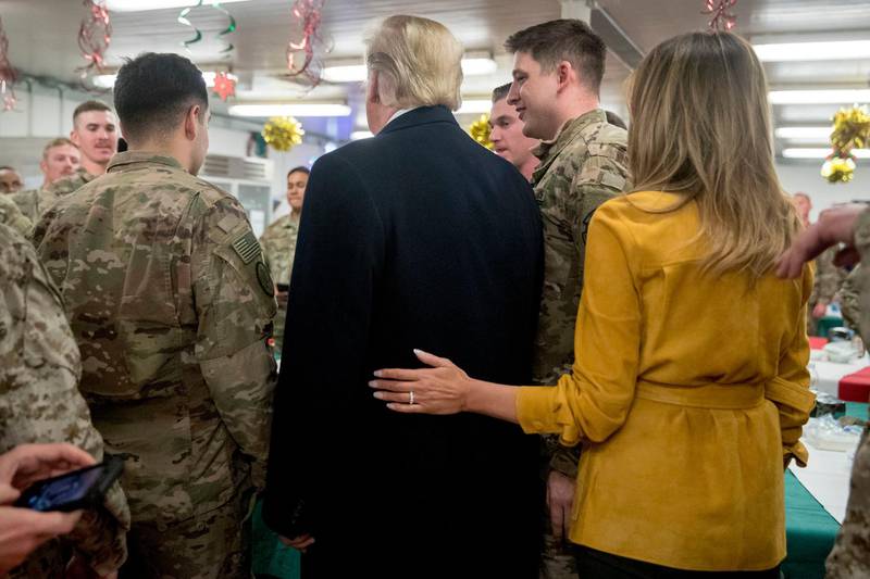 President Donald Trump and first lady Melania Trump pose for a photograph as they visit with members of the military at a dining hall at Al Asad Air Base, Iraq. AP Photo