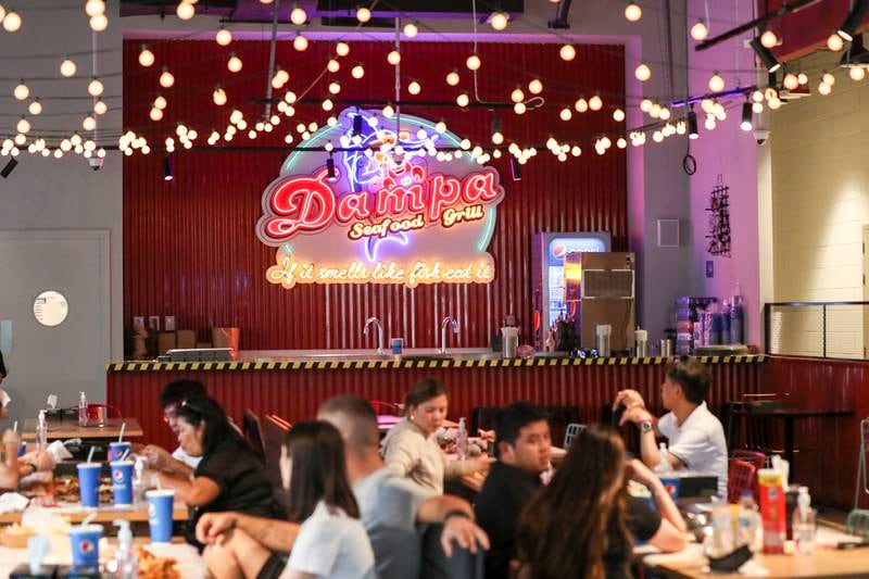 The interior space of Dampa Seafood & Grill has a carnival atmosphere, with fishing nets hung from the ceiling.