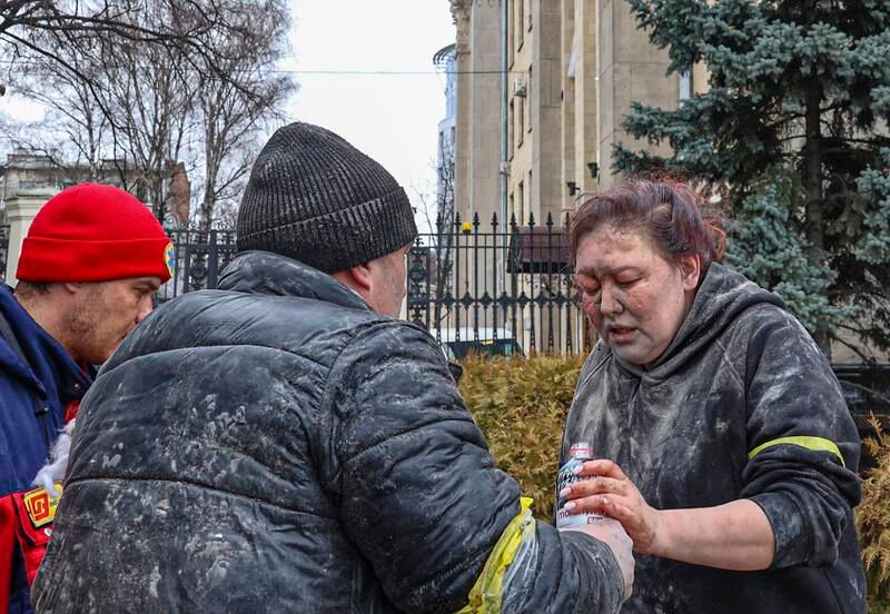 People help a wounded woman in the aftermath of Russian shelling in Kharkiv. EPA