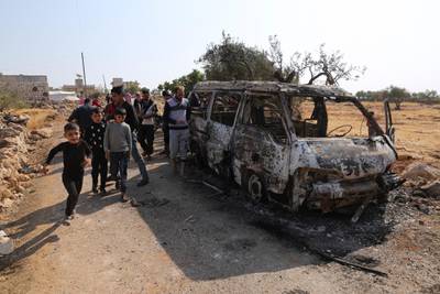 People look at a destroyed van near the village of Barisha, in Idlib province, Syria, on Sunday, October 27, 2019, after an operation by the US military which targeted Abu Bakr Al Baghdad. AP Photo