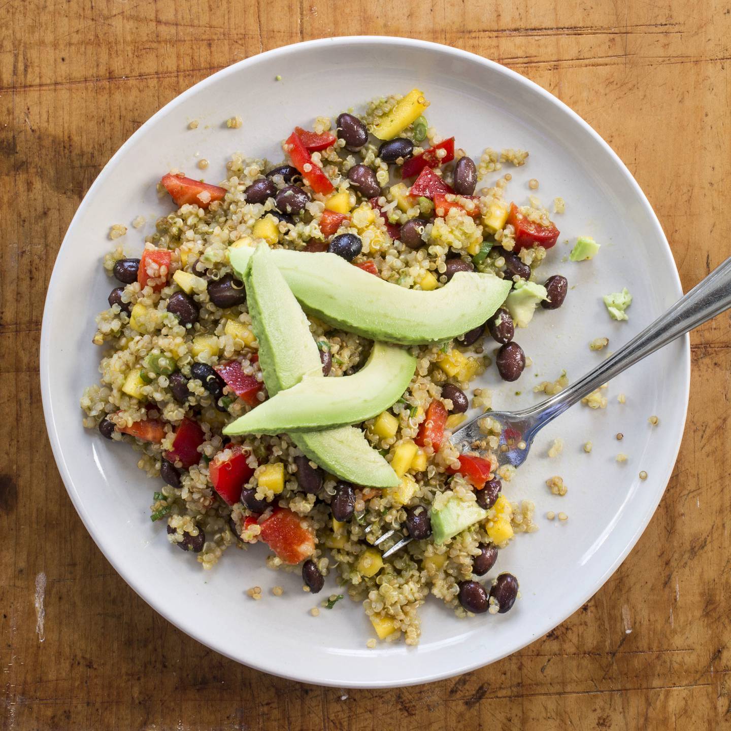 This undated photo provided by America's Test Kitchen in May 2018 shows a quinoa, black bean and mango salad in Brookline, Mass. This recipe appears in the cookbook â€œVegan For Everybody.â€ (Daniel J. van Ackere/America's Test Kitchen via AP)