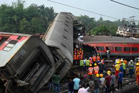 Rescue workers gather around damaged carriages at the site of a three-train collision near Balasore in Odisha. AFP