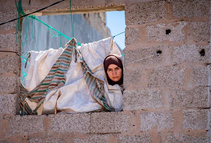 A Moroccan woman confined at home, peeks out a window in the southern port city of Safi during a lockdown ordered by the authorities following the detection of several new Covid-19 cases.  AFP