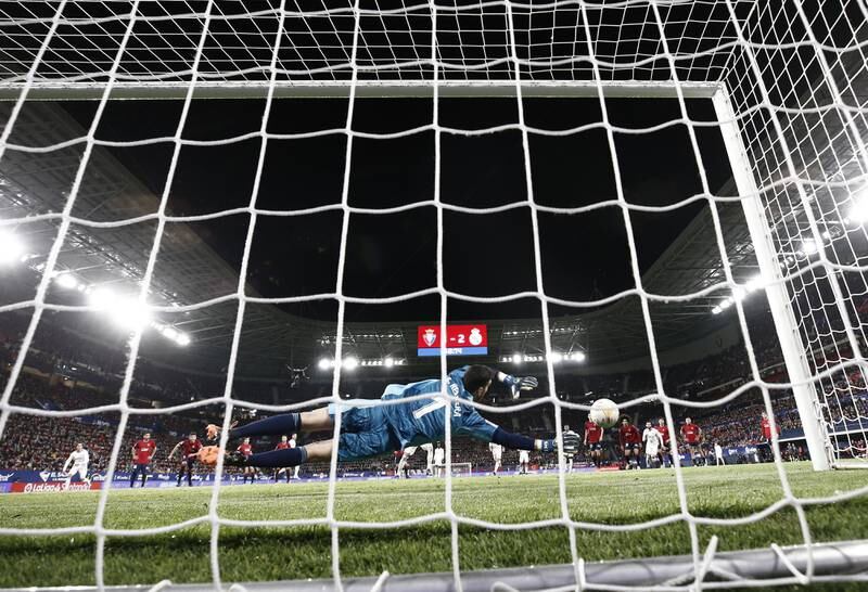 Osasuna goalkeeper Sergio Herrera dives to save the second penalty kick from Karim Benzema. EPA