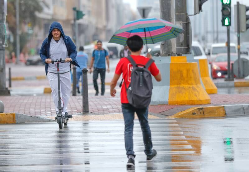 Abu Dhabi, United Arab Emirates, November 20, 2019.   UAE weather: rainfall and storms arrive at downtown Abu Dhabi.--  Abu Dhabi residents cross the intersection of Hazza Bin Zayed The First St. and Sultan Bin Zayed The First St. during a rain shower.Victor Besa / The NationalSection:  NAReporter: