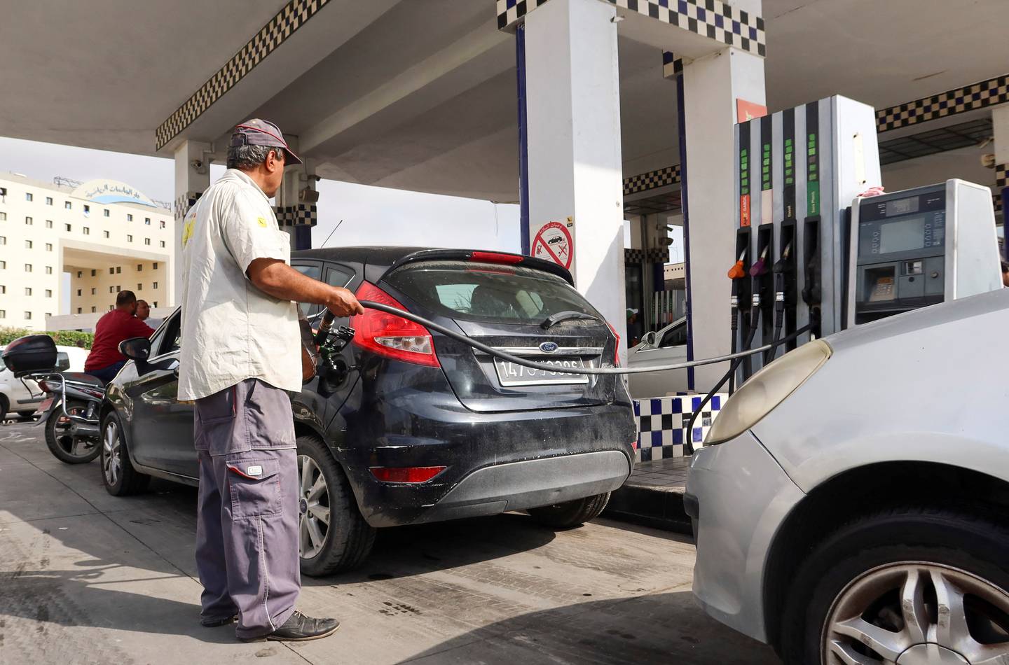 A gas station attendant pumps fuel into a customer's car at a gas station in Tunis, Tunisia 