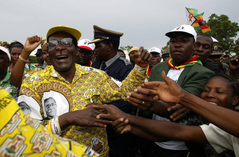 Zimbabwe president Robert Mugabe and leader of the ruling party ZANU PF greets a crowd of about 15,000 people at a golf course in Chinhoyi town some 120Km northwest of Harare during a pre-election rally.AFP PHOTO Alexander JOE / AFP PHOTO / ALEXANDER JOE