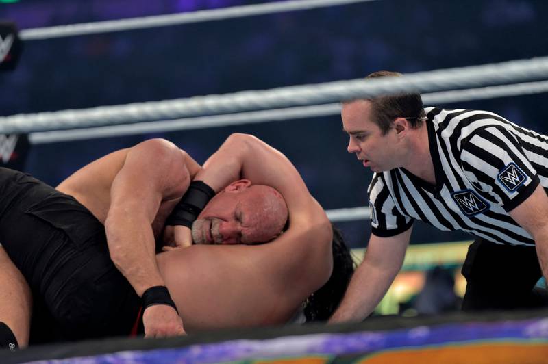 Roman Reigns, bottom, wrestles with Bill Goldberg.