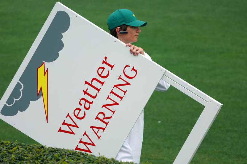 Weather warning signs are brought out on the range during a practice round. AFP