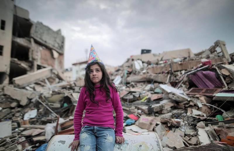 A Palestinian child amid the rubble in Gaza. The writer of this essay had grown up hearing stories about love and loss in Palestine. Belal Khaled