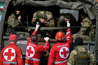 Members of the Hellenic Red Cross check the temperature of Greek soldiers who wait to enter the Kastanies border crossing area with Turkey's Pazarkule, Greece. Reuters