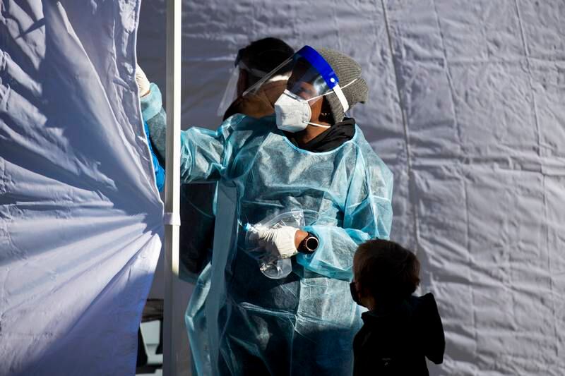 A child watches a Covid-19 test being administered in Washington, DC. EPA