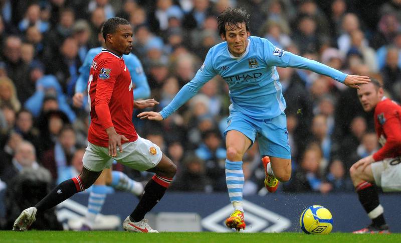 Manchester United's French defender Patrice Evra (L) vies with Manchester City's Spanish midfielder David Silva during the FA Cup third round football match between Manchester City and Manchester United at The Etihad stadium in Manchester, north-west England on January 8, 2012. AFP PHOTO/ANDREW YATES. RESTRICTED TO EDITORIAL USE. No use with unauthorized audio, video, data, fixture lists, club/league logos or “live” services. Online in-match use limited to 45 images, no video emulation. No use in betting, games or single club/league/player publications. (Photo by ANDREW YATES / AFP)