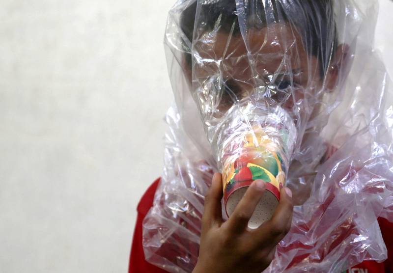 A boy tries on an improvised gas mask in Idlib. Reuters