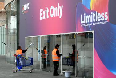 Workers cleaning glass doors at the MWC venue in Barcelona on Wednesday. Organisers have cancelled the event after the exodus of participants because of coronavirus outbreak. AFP