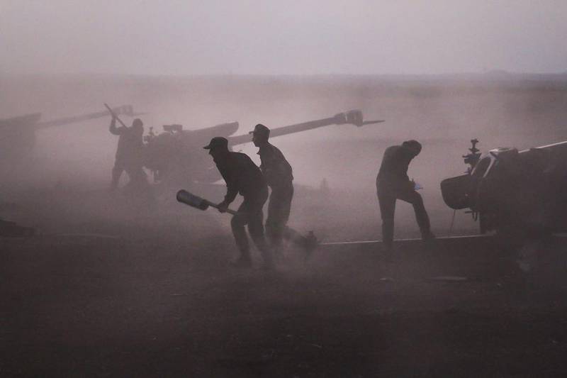 Syrian army personnel load howitzers last week. Alexander Kots / AP