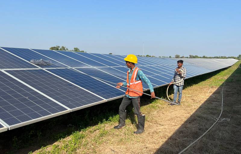 Workers clean panels at a solar park in the western Indian state of Gujarat. Reuters