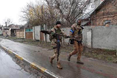 Ukrainian soldiers walk the streets of Bucha after reclaiming it from Russian forces. EPA