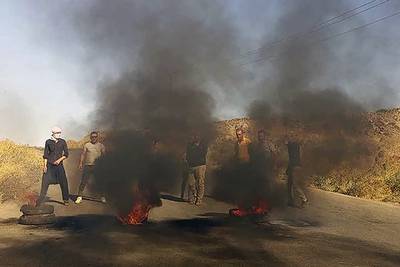 Protestors block a road in the mostly Druze Syrian southern area of Suweida, Syria, August 22, 2023. Suwayda24 via AP