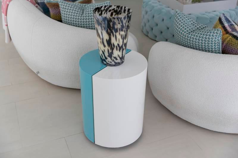 A turquoise and white accent table houses an oversized Baobab Collection candle in the seating area. Antonie Robertson / The National
