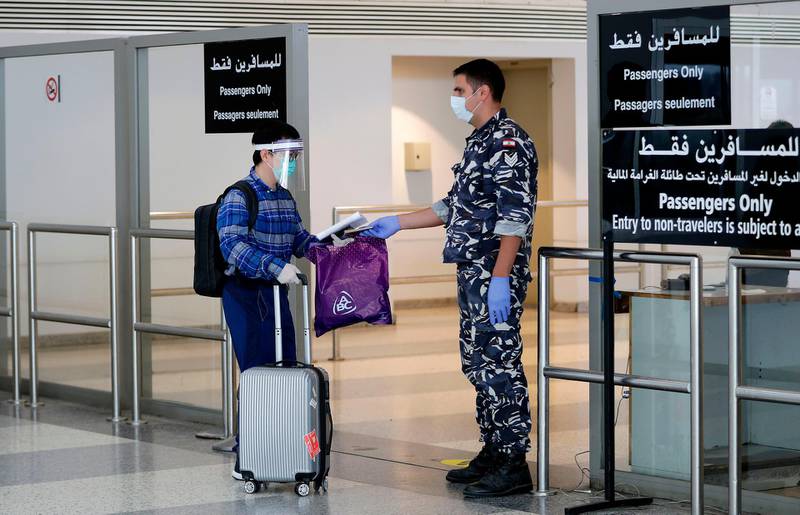 Passengers and officials wearing protective face masks against Covid-19 are pictured at Beirut international airport as it re-opens. AFP