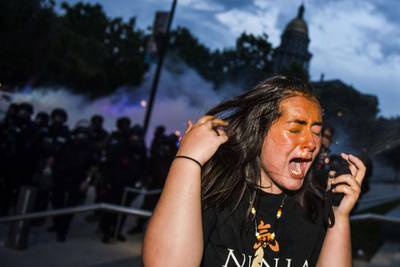 A woman reacts after being sprayed by pepper spray in Denver, Colorado. Getty Images