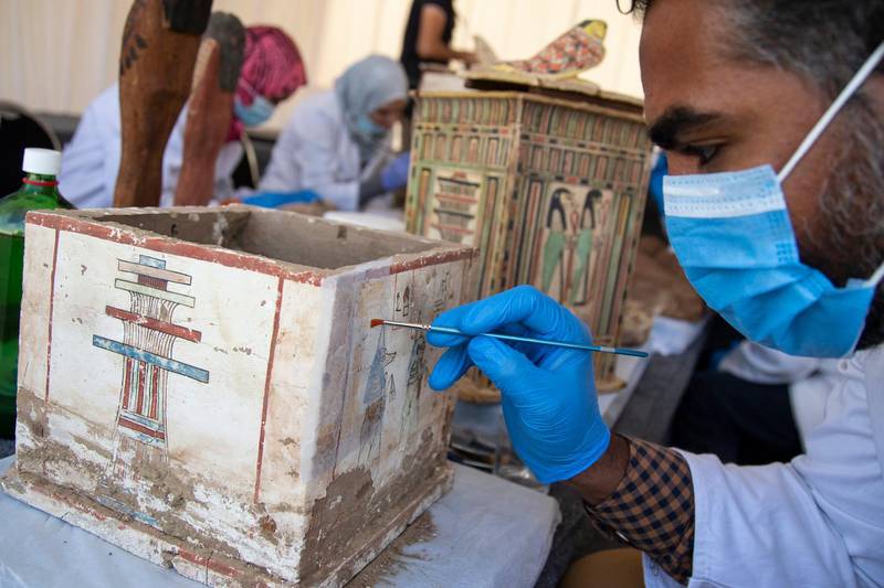 An archaeologist works on an artefact as sarcophaguses are presented to the media near the newly discovered burial site at Saqqara Necropolis in Giza. EPA
