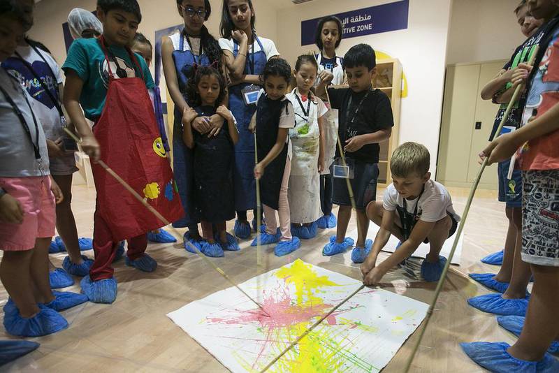 Children use unconventional materials such as sticks to create abstract art at the Guggenheim workshop. Mona Al Marzooqi / The National