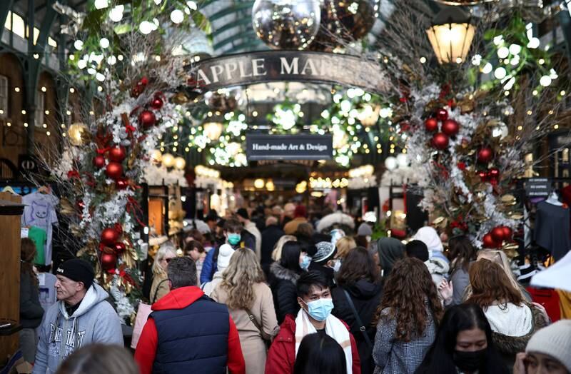 Crowds of people, some wearing face masks, walk through Covent Garden in central London. Authorities in England are attempting to stem the spread of the new Omicron variant. Reuters