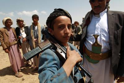An Armed Yemeni boy loyal to the Shiite Huthi movement poses for a picture during a tribal gathering against al-Qaeda militants in the Bani al-Harith area, north of Sanaa, on August 17, 2014. Yemen faces multiple domestic problems, including ongoing insecurity and insurgencies posed by Shiite Houthi fighters, southern separatists and the al-Qaeda in the Arabian Peninsula (AQAP).  AFP PHOTO / MOHAMMED HUWAIS (Photo by MOHAMMED HUWAIS / AFP)