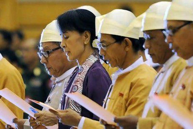 Myanmar opposition leader Aung San Suu Kyi, along with other elected members of parliament reads her parliamentary oath at the lower house of parliament during a session in Naypyidaw today.